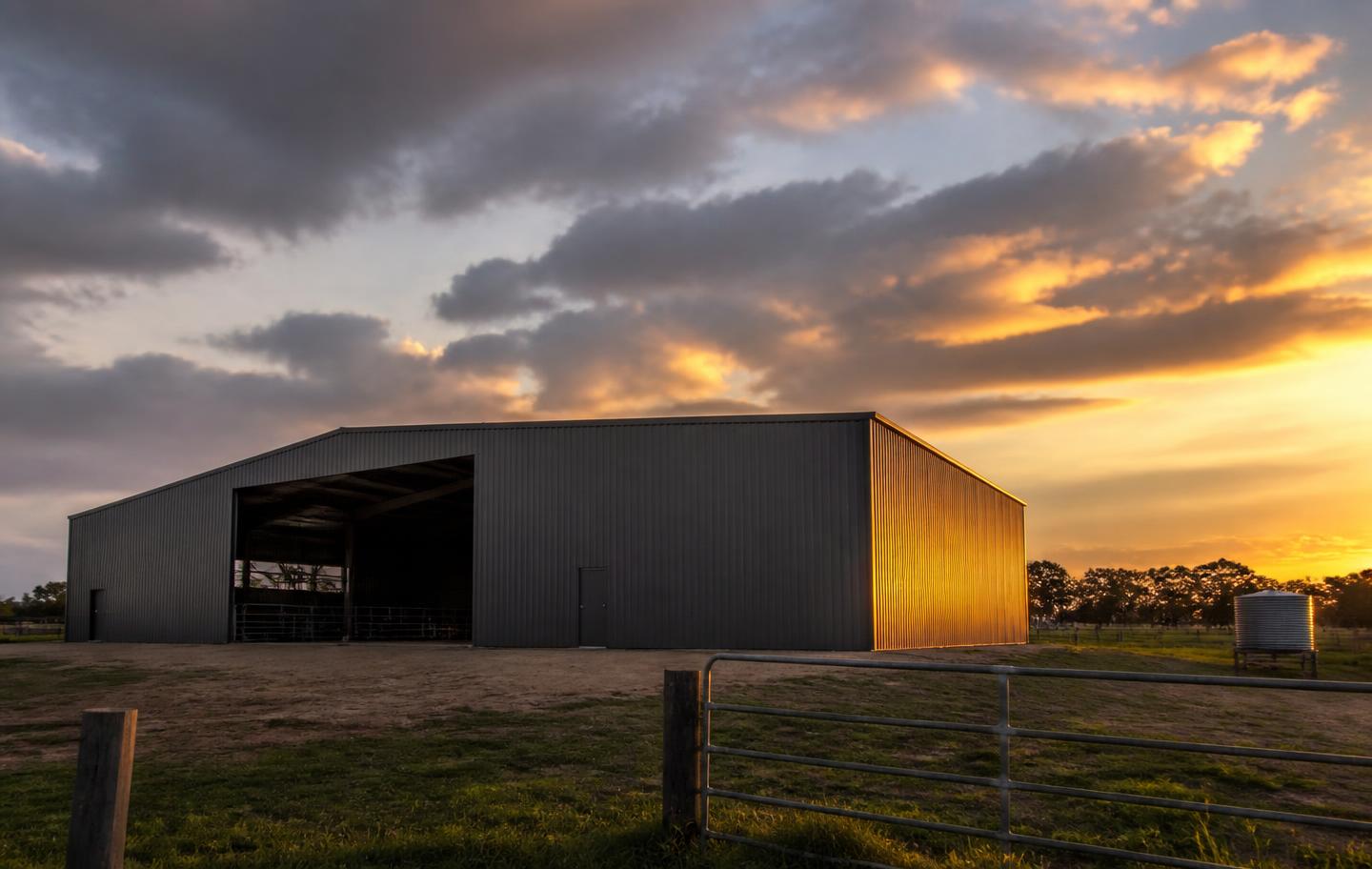 Large colorbond farm machinery shed at sunset on a Gulgong property